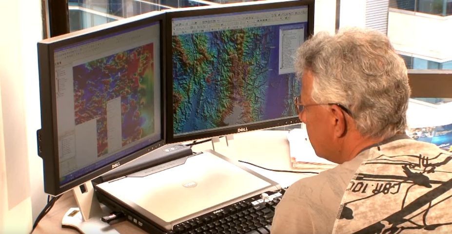 Foto hombre trabajando en computador con mapas